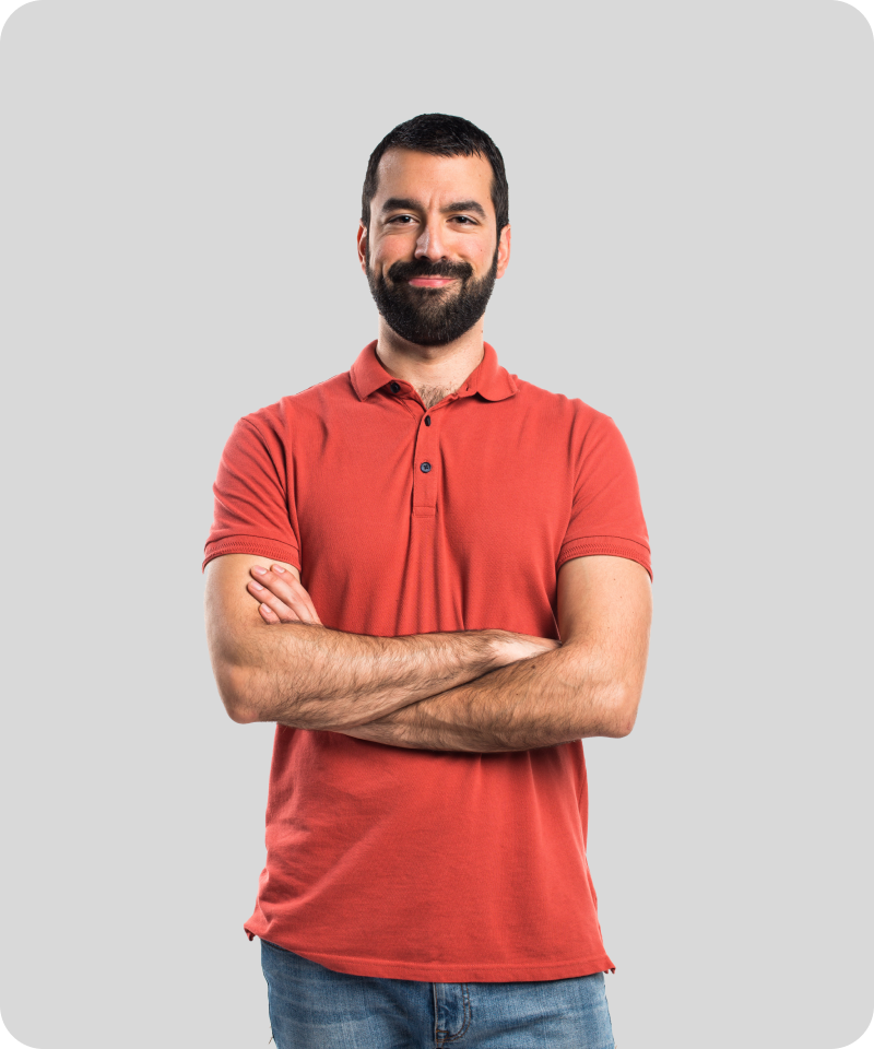 Confident man in a red polo shirt with folded arms standing against a light grey background 